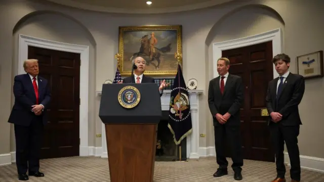 SoftBank CEO Masayoshi Son speaks at a lectern in the White House, with Trump and other tech execs standing nearby