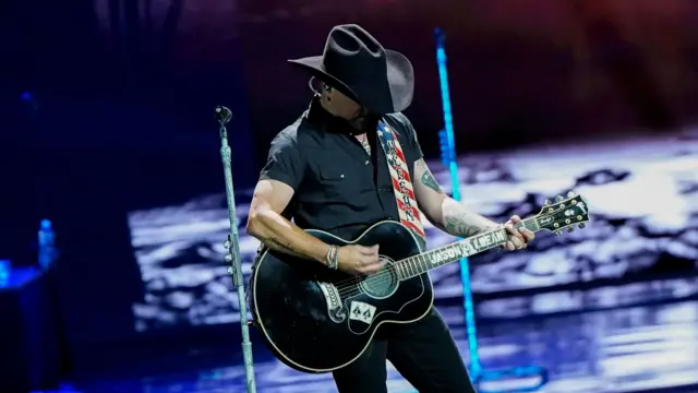 Aldean plays the guitar on stage