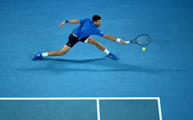 Novak Djokovic stretches for a backhand