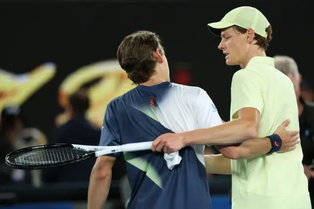 Alex de Minaur and Jannik Sinner hug at the net