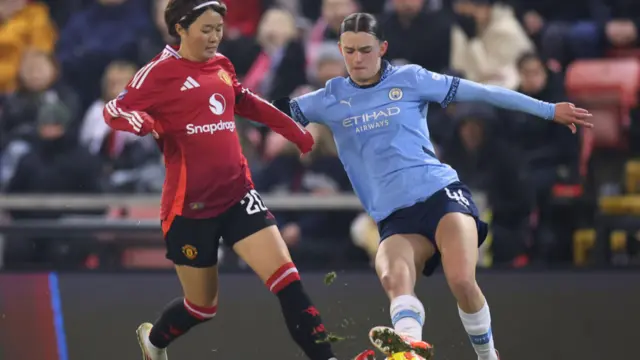 : Hinata Miyazawa of Manchester United battles for possession with Lily Murphy of Manchester City during the Subway Women's League Cup match between Manchester United and Manchester City