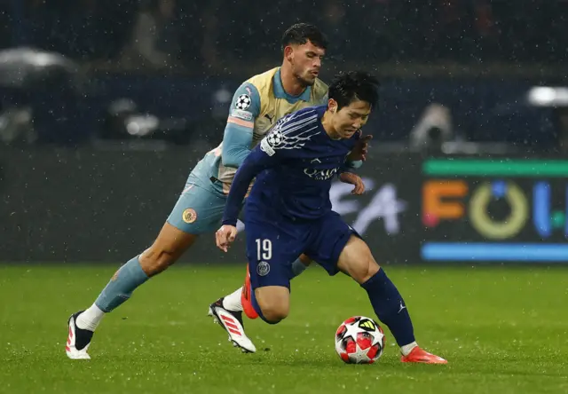 Paris St Germain's Lee Kang-in in action with Manchester City's Matheus Nunes