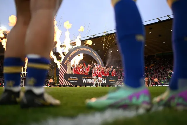 Chelsea players watch on as Arsenal lift the league Cup