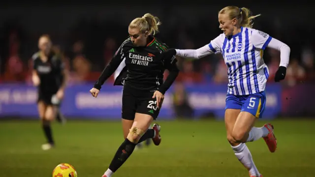 Alessia Russo of Arsenal runs with the ball whilst under pressure from Guro Bergsvand of Brighton & Hove Albion during the Subway Women's League Cup match between Brighton & Hove Albion and Arsenal