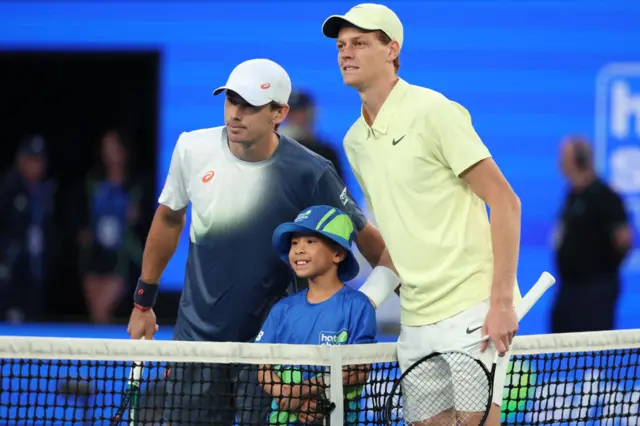 Jannik Sinner and Alex de Minaur pose with a mascot