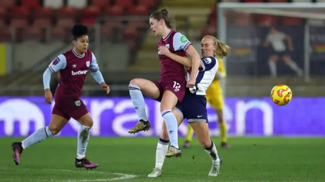 Emma Harries of West Ham United is challenged by Molly Bartrip of Tottenham Hotspur during the Subway Women's League Cup match between Tottenham Hotspur and West Ham United