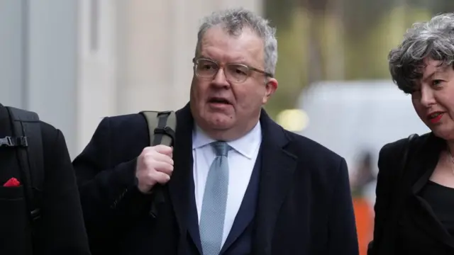 Tom Watson in suit arriving at court