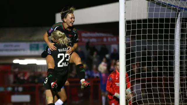 Katie McCabe of Arsenal celebrates scoring her team's second goal with teammate Alessia Russo during the Subway Women's League Cup match between Brighton & Hove Albion and Arsenal