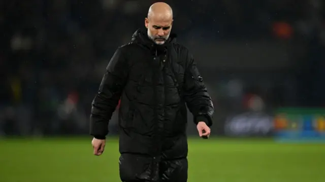 Pep Guardiola walking with his head down