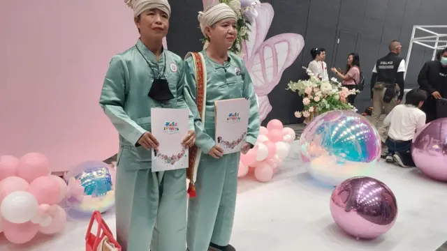 Paungpetch Hengkum (left) and Permsub Saiaung pose with their marriage certificates