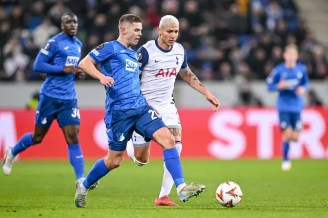 Becker plays the ball ahead of Richarlison's challenge