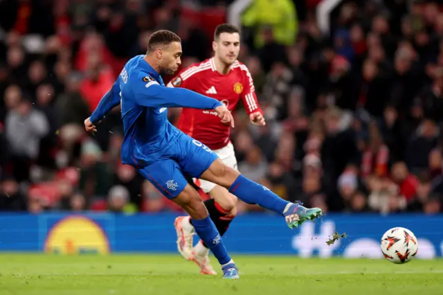 Cyriel Dessers of Rangers FC scores his team's first goal during the UEFA Europa League 2024/25 League Phase MD7 match between Manchester United and Rangers FC at Old Trafford