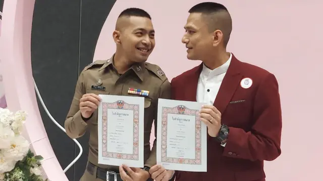 Pisit Sirihirunchai (left) and Chanatip Sirihirunchai hold up their marriage certificates