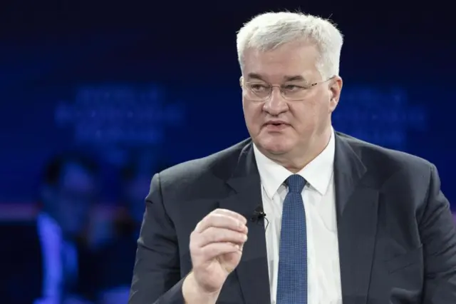 Ukraine's foreign minister Andriy Sybiha speaking at the World Economic Forum in Davos, gesturing with his hand and looking to the left. Shot from chest up, wearing a dark suit and blue tie