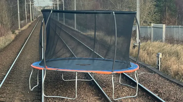 A trampoline has blown onto a railway line.