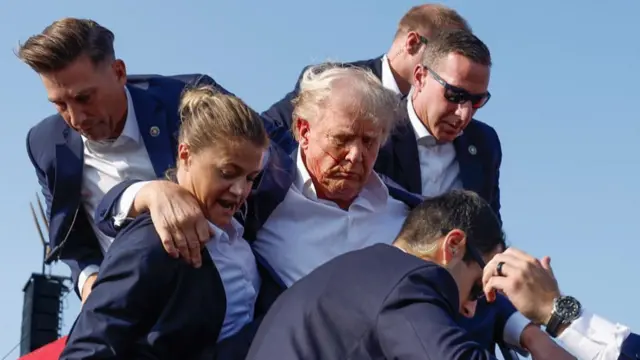 Curran (seen wearing sunglasses to the right of Trump) defended him during the assassination attempt in July