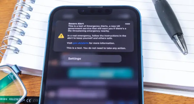 A stock image of an iPhone with a emergency alert.