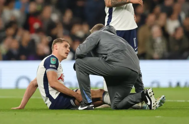 Van de Ven explains his injury to a physiotherapist while sitting on the pitch