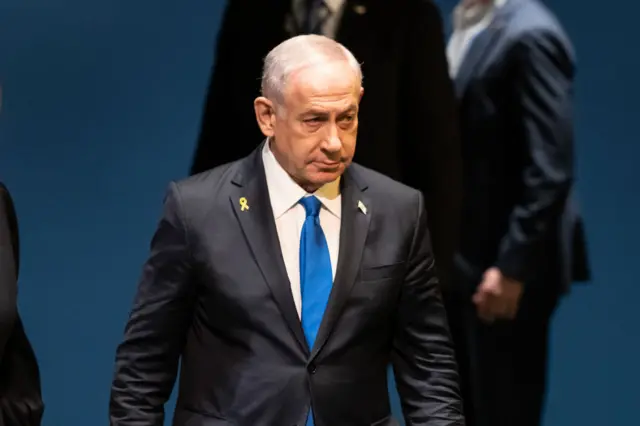 Benjamin Netanyahu in a black suit with blue tie