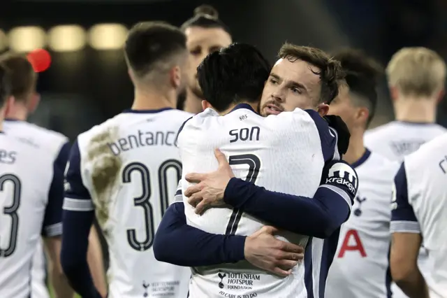 Son and Maddison hug in celebration with teammates behind them after their goals