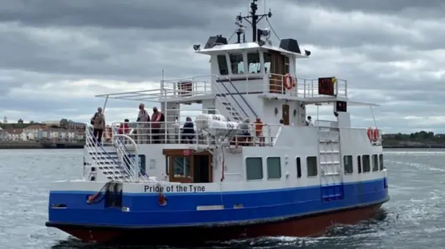 The blue and white ferry is sailing on the water. Painted text on the side of the vessel reads: "Pride of Tyne".