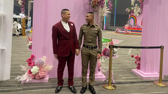 Police officer Pisit "Kew" Sirihirunchai (R) with his partner Chanatip "Jane" Sirihirunchai at the Siam Paragon mall, where they are waiting to register their marriage