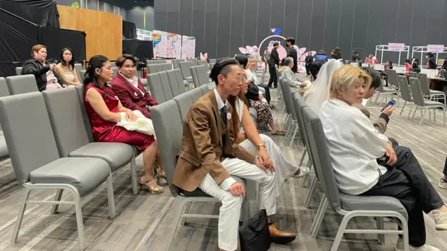 Couples wait for resgitration to begin at the mall