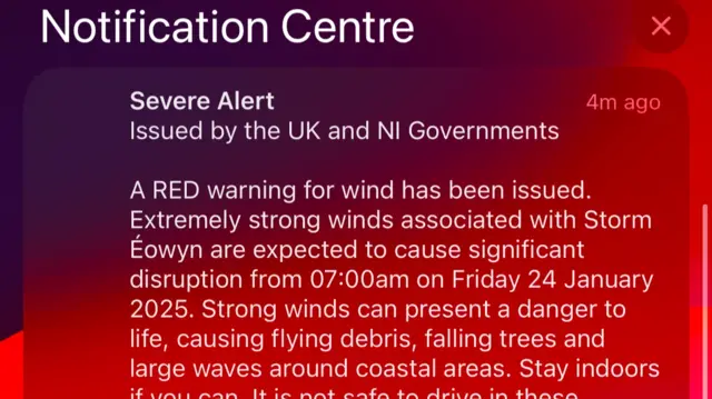 A screenshot of an emergency alert message on a phone screen. The message is warning people of severe weather during Storm Éowyn and asking them to stay indoors while the red weather warning is ongoing.