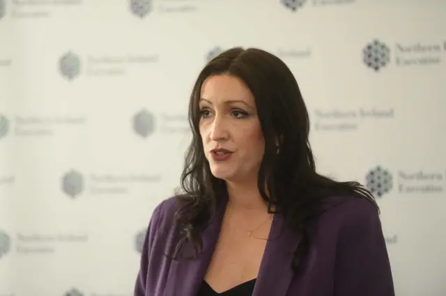 Emma Little Pengelly wears a purple jacket as she speaks at a press conference on the storm. She has brown hair and brown eyes.