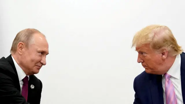 Vladimir Putin leans towards Donald Trump to shake his hand in a black suit.