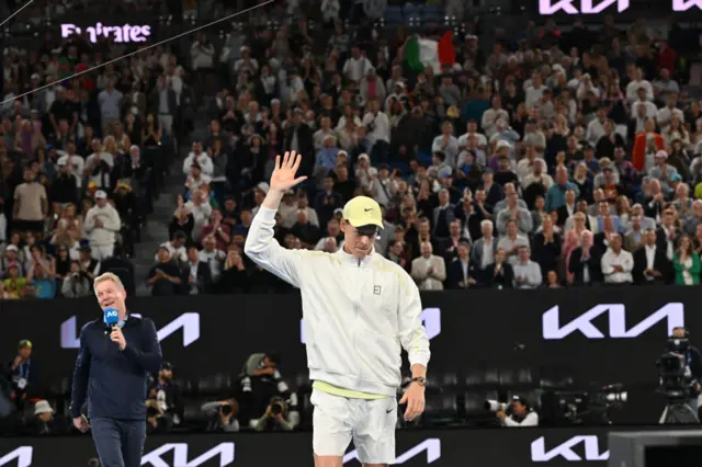 Jannik Sinner holds up his hand in appreciation to the crowd