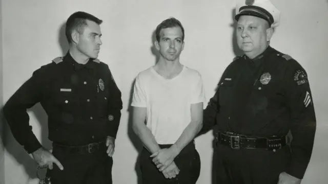 Lee Harvey Oswald (centre) after being captured by Dallas police in 1963