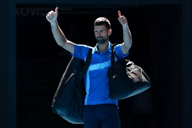 Novak Djokovic of Serbia acknowledges the crowd as he leaves the court after retiring