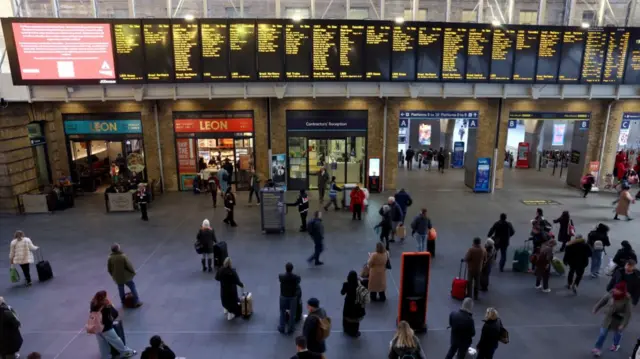 Commuters look at the information board in King's Cross