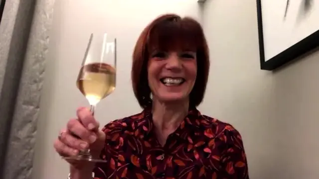 Diane Carson holding a glass of fizzy rosé