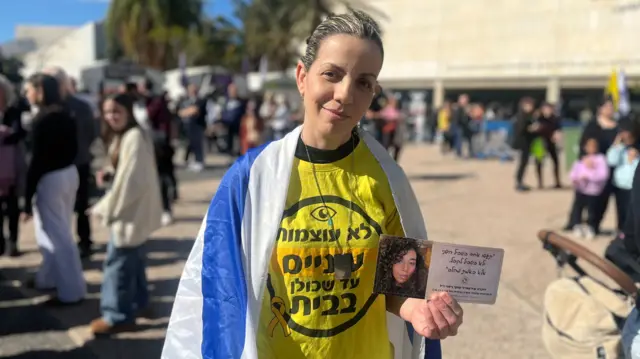 Merav Gilad holds a picture in Tel Aviv