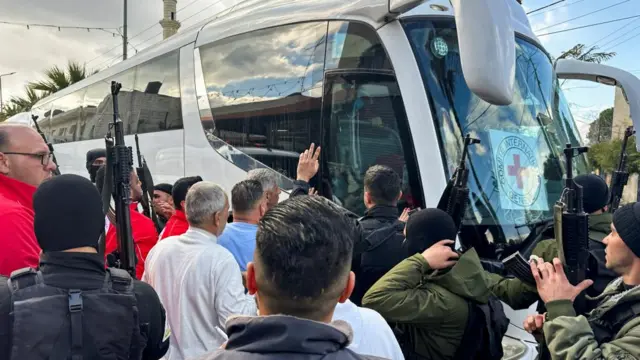 People gather near a bus carrying freed Palestinian prisoners after they were released from an Israeli jail