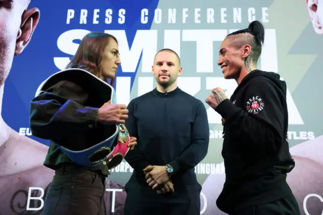 Ellie Scotney faces off with a smiling Mea Motu at a news conference