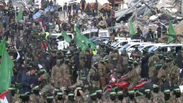 Palestinian Hamas fighters gather as they prepare to release hostages who had been held in Gaza since the deadly October 7, 2023 attack