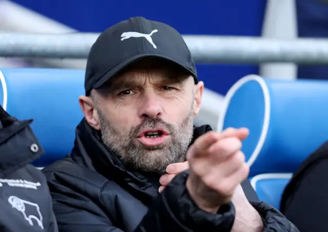 Derby manager Paul Warne sat in the dugout watching the game with Cardiff