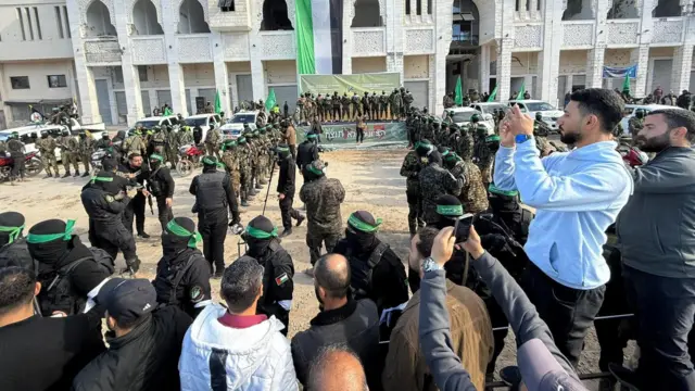 crowds gather next to Hamas fighters