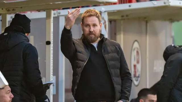 Crawley Town boss Rob Elliot signalling his team from the dugout