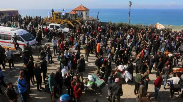 Palestinians wait for their relatives at the Netzarim Corridor, which separates the north from the south of the Gaza Strip and is home to tanks and military vehicles belonging to the Israeli army