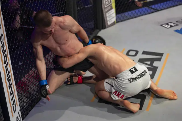 Paul Hughes fights off Usman Nurmagomedov on the ground