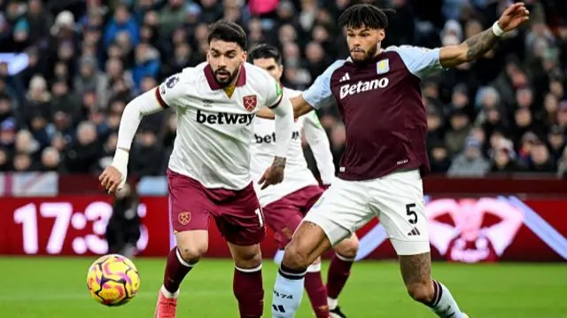 Lucas Paqueta of West Ham United is challenged by Tyrone Mings