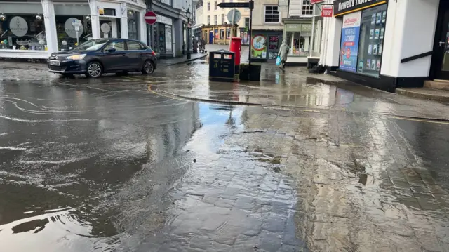 A town road junction under water in parts.