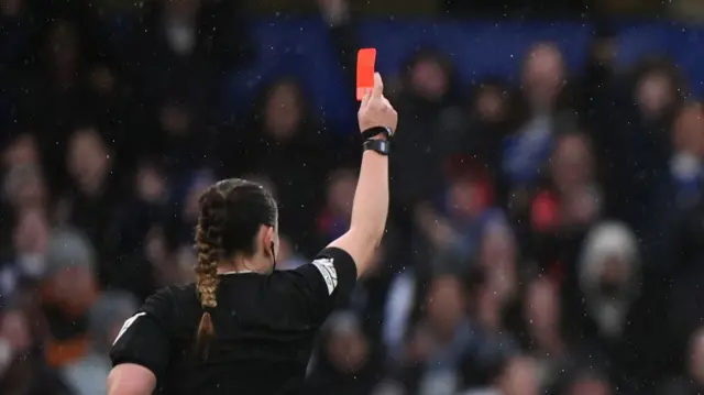 Arsenal's Katie McCabe (right) is shown a red card for a challenge which leads to a penalty kick for Chelsea, shown by referee Emily Heaslip during the Barclays Women's Super League match at Stamford Bridge