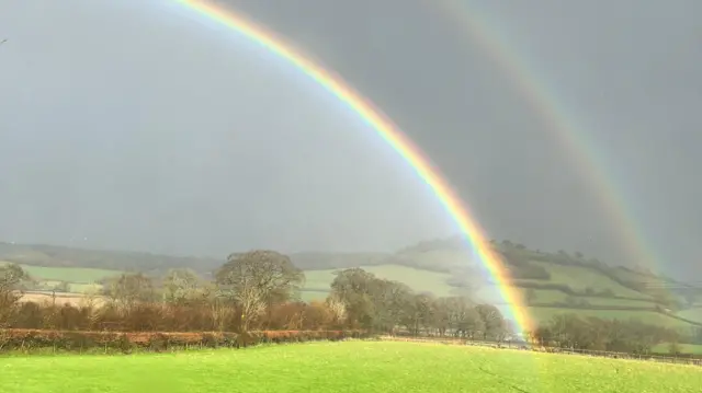 A double rainbow spotted over fields.