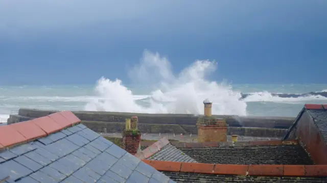 Strong waves seen off the coastline in Cornwall with houses in the foreground