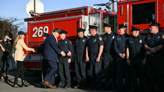 US President Donald Trump and First Lady Melania Trump shake hands with firefighters from Station 69 as they tour a fire area in Pacific Palisades, a neighborhood of Los Angeles